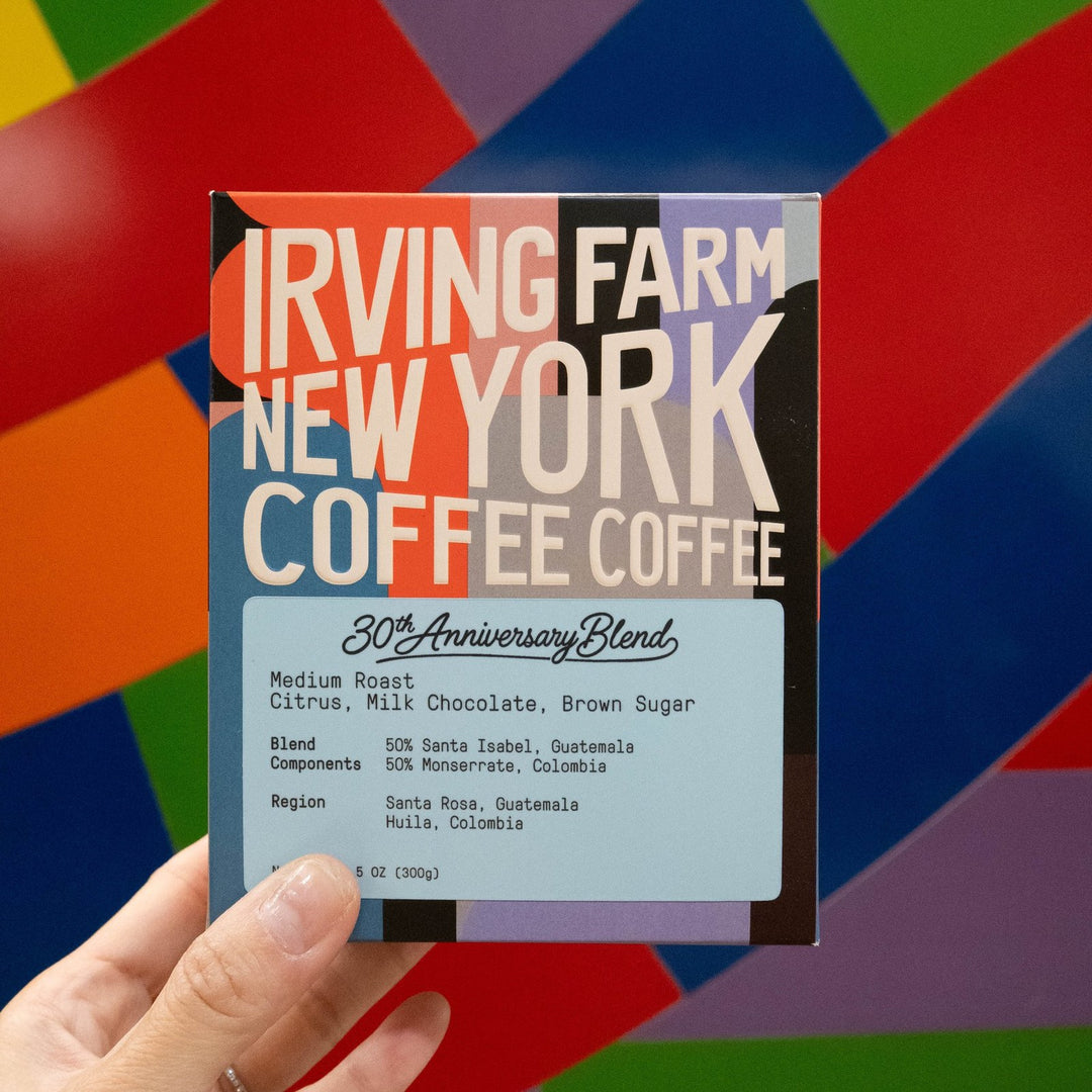 30th Anniversary Blend box held up in front of a colorful New York mural, 4 of 4